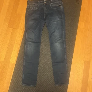 Replay Hyperflex jeans blå 31/32 - Säljer ett par mörkblå Replay Hyperflex jeans i storlek 31/32. De har klassisk femficksdesign, smal passform och stretchigt material som ger grym komfort. Snygga slitningar och detaljer vid fickorna. Perfekta för dig som gillar stilrena och moderna jeans.