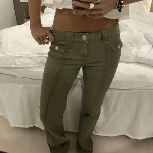Olivgröna lågmidjade bootcut byxor - Säljer dessa snygga populära jeansen från hm. Olivgröna byxor med låg midja och bootcut-ben. Skriv för frågor eller mer bilder. Endast använda ett fåtal gånger🩷