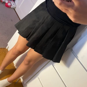 Svart plisserad kortkjol - Supertrendig svart kjol med veck – ger den perfekta schoolgirl/preppy looken! Sitter snyggt i midjan och faller fint. Storlek: XL men passar M–L då den är liten i storleken  Fint skick 💫  🖤 Lätt att styla med både hoodie eller croptop – passar alla säsonger!