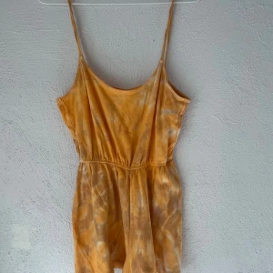Gul batikklänning från H&M Divided XS - Snygg kort gul batikklänning från H&M Divided i storlek XS. Klänningen har smala axelband, markerad midja och ett flowy fall. Tillverkad i mjuk bomull, perfekt för varma dagar. Batikmönstret ger en chill och trendig vibe.