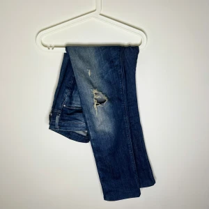 Armani Jeans blå slitna jeans W30 L34 - Blå jeans från Armani Jeans med snyggt sliten look och hål på låret. Klassisk femficksmodell i bomull, tillverkad i Afrika. Jeansen har en rak passform och tydliga slitningar för en cool vibe. Frågor/funderingar hör av dig 🤙🏽 