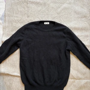 Svart kashmirtröja från Soft Goat - Mjuk och stilren svart tröja från Soft Goat i 100% kashmir. Rund halsringning och långa ärmar ger en klassisk look. Perfekt för dig som gillar minimalistisk stil och vill ha något riktigt skönt och varmt.