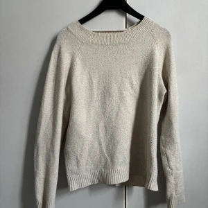 Beige stickad tröja - En stilren beige stickad tröja med rund halsringning och ribbade muddar. Perfekt för lager-på-lager och enkel att matcha med jeans eller kjol. Långärmad och mjuk, passar dig som gillar en clean och avslappnad look.