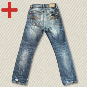 Nudie Jeans Loose Leif Selvedge  - Riktigt snygga Nudie Loose Leif i japanskt selvedge-tyg från Kaihara. Storlek 27/32. Washade av Nudie med snygga fabriksslitage. Loose Leif är en äldre och eftertraktad modell som inte görs längre – detta par är dessutom ovanligt sällsynt!  Mått: Midja – 38 cm, Innersöm – 79,5 cm, Yttersöm – 107 cm, Lår – 26 cm, Benöppning – 20 cm.