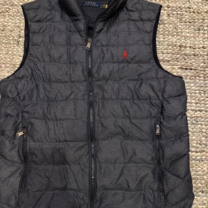 Blå dunväst från Polo Ralph Lauren - Blå quiltad dunväst från Polo Ralph Lauren. Storlek S (Herr).