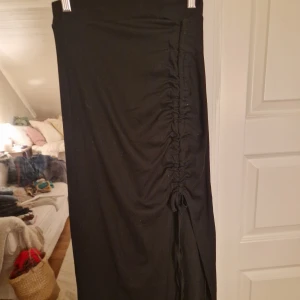Kjol - Svart kjol med slits. Kan välja hur mycket slits man vill ha. Köpt på smögen bryggan, så finns inget märke 