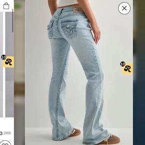 Ljusblå True Religion bootcut jeans - Säljer ett par ljusblå jeans från True Religion med ikoniska bakfickor med lock och broderad logga. Jeansen har bootcut passform och klassisk femficksdesign. Perfekt för dig som gillar en avslappnad men ändå snygg stil. Byxorna är uppsydda 5cm i benen och passa mig som är 166cm perfekt i längden❤️ använda 2 gånger och inga tecken på användning, I modellen Joey