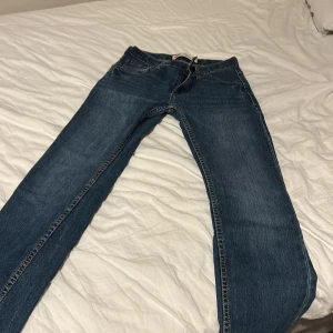Levi's 511 Slim jeans blå - Säljer ett par Levi's 511 Slim jeans i klassisk blå färg. Modellen har smal passform, fem fickor och snygga kontrastsömmar. Jeansen är tillverkade i slitstarkt denim och har normal midja. Perfekt för dig som gillar en modern och stilren look. Säljer pågrund av att de är för små