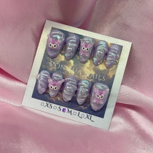 PurpleKuromi (M);Short Almond;Curved - Handgjorda press-on naglar i lila med skimrande finish, dekorerade med 3D Kuromi-figurer, hjärtan och vita linjer. Naglarna har en kort mandelform och är perfekta för dig som vill ha en söt och unik look. M: 16 mm, 12 mm, 12,5 mm, 11,5 mm, 10 mm, och designen är superkawaii.