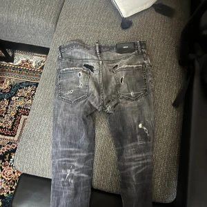 Grå slitna jeans med hål - Riktigt snygga grå jeans med slitningar och hål på både fram- och baksida. Jeansen har en smal passform och coolt tvättad look. Perfekta för dig som gillar en edgy streetstil.