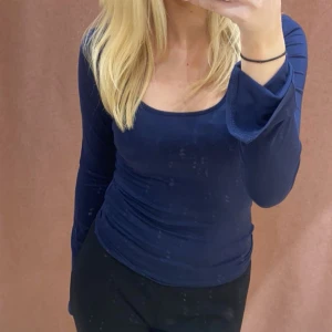 Mörkblå långärmad topp - Säljer en mörkblå långärmad topp med rundad halsringning. den kom inte till använidning. Storlek M