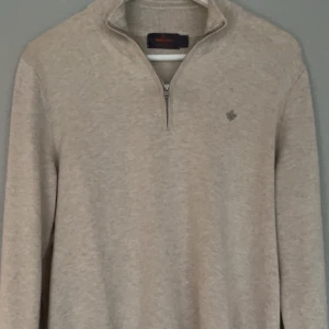 Morris half-zip - Säljer en stilren beige tröja från Morris i 100%  pima bomull. Tröjan har half zip-dragkedja, lång ärm och en broderad logga på bröstet. Perfekt för lager-på-lager och passar till både jeans och chinos. Tröjan är använd 1 gång och är som ny. Pris kan diskuteras vid snabb affär. 