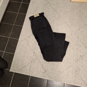 Svarta jeans från Nudie Jeans W31 L32 - Säljer ett par svarta jeans från Nudie Jeans i storlek W31 L32. Byxorna är tillverkade av 100% ekologisk bomullsdenim och har en klassisk rak passform. Snygga och stilrena jeans som passar perfekt till din vardagsstil.