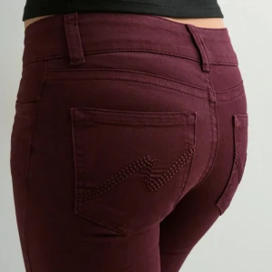 Två st Low Waist Bootcut Stitch jeans paketpris  - Nya oanvända jeans med etikett kvar. Low Waist Bootcut Stitch, vinröda och bruna från Nelly.com. Storlek 34 i båda, Ordpris 699kr. Innerbenslängd ca 84 cm. Paketpris för båda 