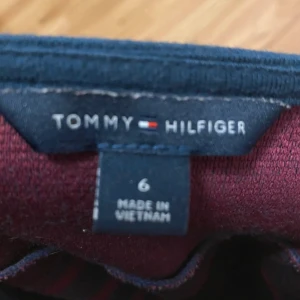 Randig klänning från Tommy Hilfiger strl S - Snygg ärmlös klänning från Tommy Hilfiger i marinblått och vinrött. Fin klänning perfekt nu till jul❤️🎄