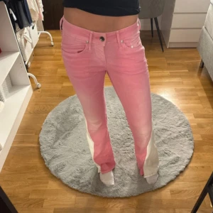 Rosa lågmidjade jeans  - Super snygga rosa jeans som är utsydda med vitt , inte perfekt sytt se bilder, midjemått 36 men e stretchiga , innerbenslängden 80. Jag är 170