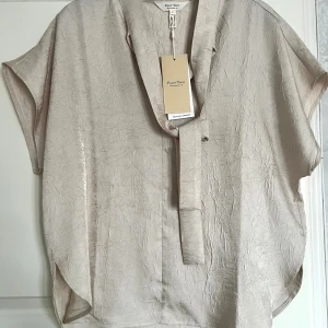 Kortärmad blus part two s/36 - Helt ny med prislapp kvar!  Skarfliknande krage att knyta vid halsen  Mönster i form av ”skrynkligt”  Nypris: 900kr   100% Polyester         #PartTwo #PartTwoBlus #PartTwoTop #PartTwoShirt #PartTwoStyle #BeigeBlus #Silkesblus #Satinblus #Ljusblus #ElegantBlus #Knytblus #KortärmadBlus #Sommarblus #Skjortblus #SkrynkligSidenlook #NordicStyle #ScandinavianFashion #Sustainab