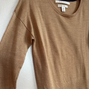 Tunn beige merinoulltröja från Max Studio - Tunn beige tröja från Max Studio i 100% extrafin merinoull. Den har rund halsringning, långa ärmar och ribbade muddar vid ärmslut och nederkant. Enkel att matcha med allt. Pyttelitet hål, se bild 5. Kan laga innan jag skickar☺️