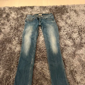 Låg midjade jeans - Snygga blå jeans från Pepe Jeans med klassisk femficksdesign och ljusa slitningar framtill. Jeansen har raka ben och normal passform, samt detaljerade bakfickor med broderad logga och läderpatch i midjan. De är jätte låg midjade 
