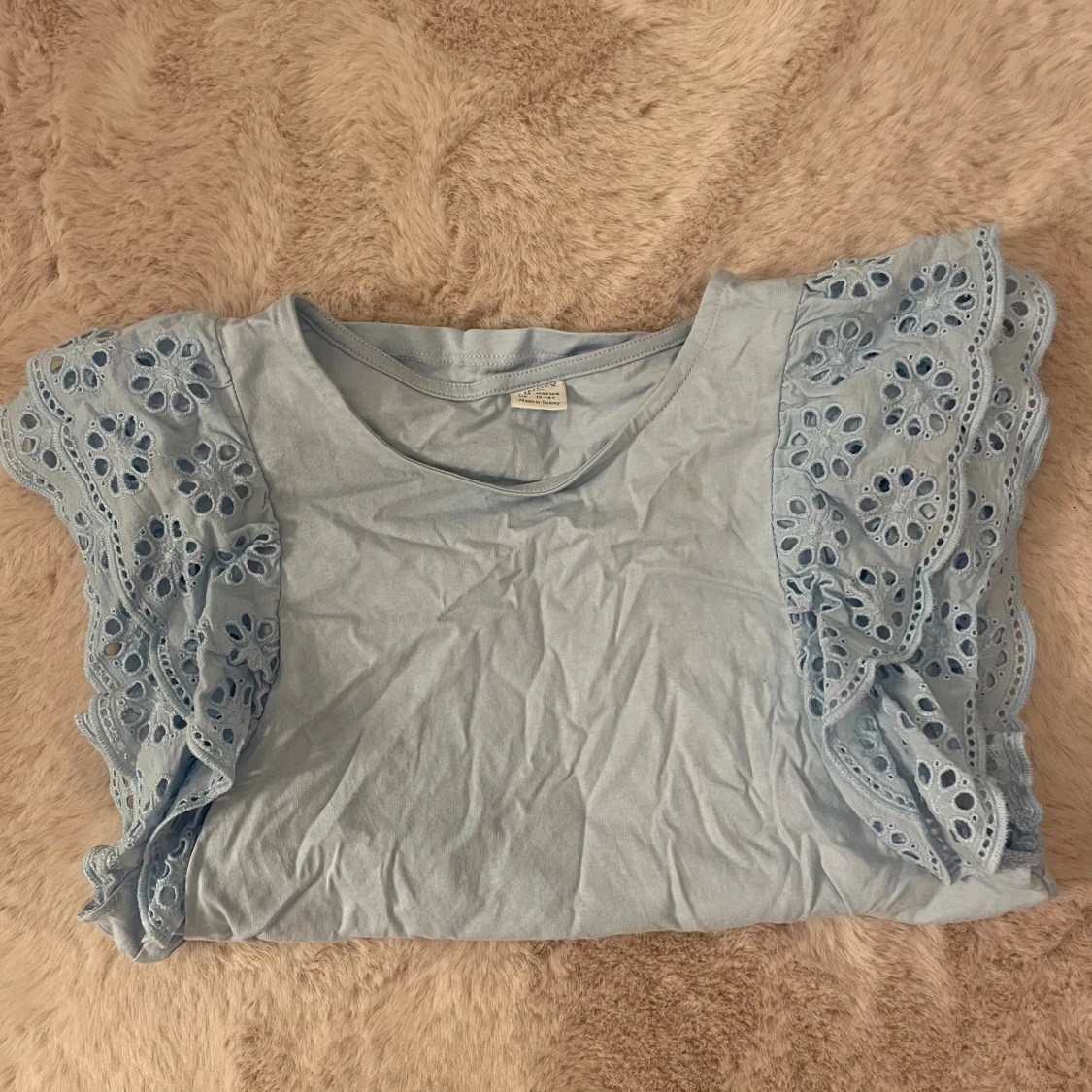 Ljusblå blus med broderade volangärmar - 1