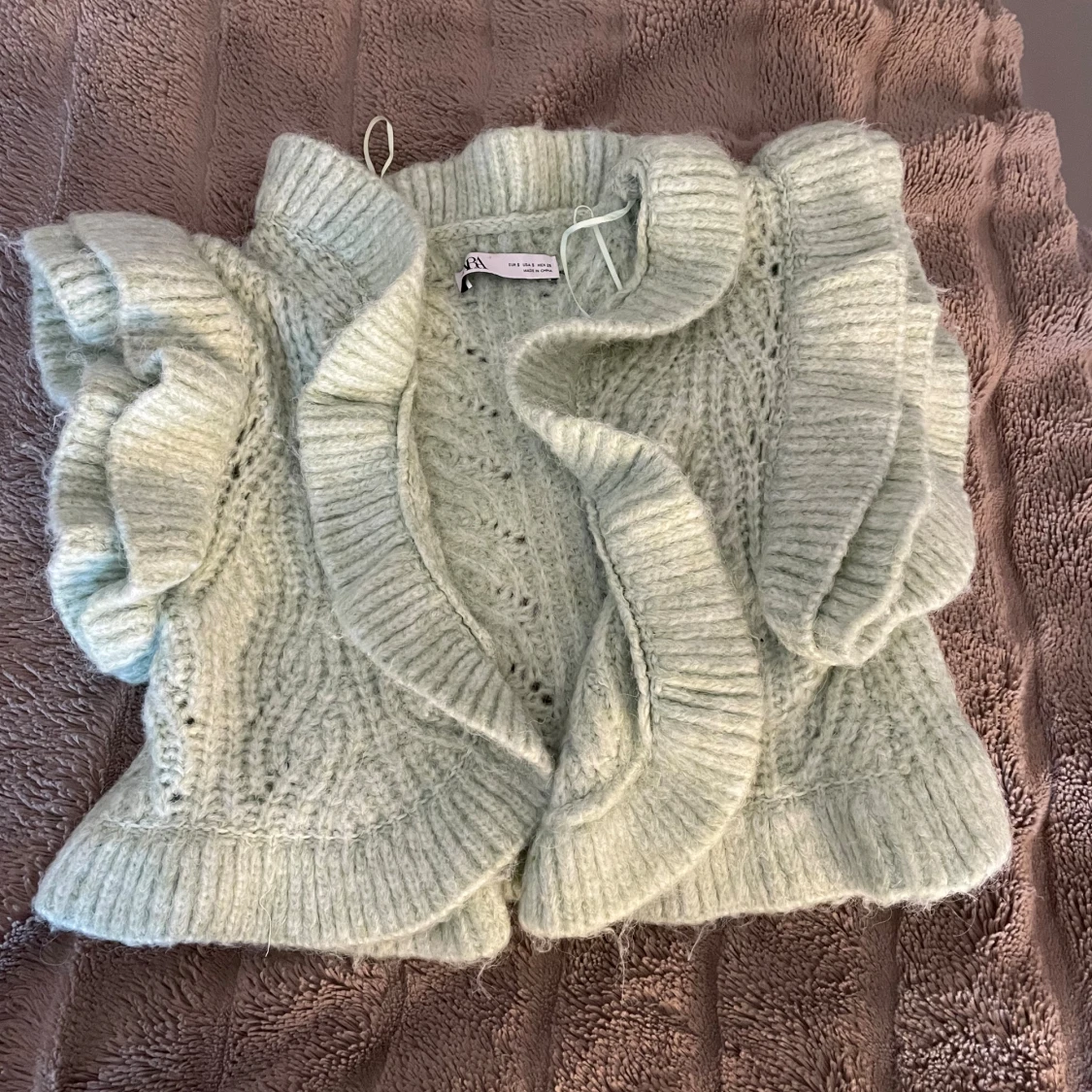 Ljusgrön stickad väst med volang - 1