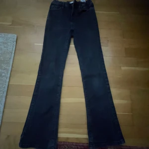 Svarta bootcut jeans med stretch - Snygga svarta jeans med bootcut-modell och klassisk femficksdesign. Jeansen har en något utsvängd passform nertill och är tillverkade i stretchigt denimtyg för extra komfort. Perfekta för dig som gillar en retroinspirerad look.