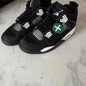 Nike Air Jordan 4 Retro White Thunder - Köpt i Stockx för några månader sedan och användt knappt för att dom passar inte längre, kommer med original box, bevis på köpet i Stockx appet och email. Säljer ett par Nike Air Jordan 4 Retro i svart och vitt. Skorna har klassisk meshpanel, Jumpman-logga på plösen och hälen, samt detaljer i vitt och svart mocka. Snygg snörning och ikonisk siluett som sticker ut. Perfekta för dig som gillar streetwear och sneakerskultur. Jordan, Air, Jordan 4