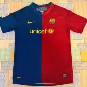 FC Barcelona fotbollströja Nike XL Kids / S Men  - Klassisk FC Barcelona matchtröja från Nike i blått och rött med gul Unicef-logga på bröstet och klubbmärke. Tröjan har korta ärmar, rak passform och är tillverkad i lätt, ventilerande material. Perfekt för dig som älskar fotboll och Barca.