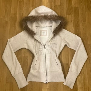 Beige hoodie med fuskpäls och dragkedja - Pälsen är påsydd av mig precis som midjan är sydd för att ha en tightare passform, därför tvätta den helst vara för hand. Dragkedjan är dubbelriktad vilket kan göra det lite jobbigt att dra upp den, men den fungerar. Finns även på min vinted, skicka ett dm för fler frågor eller bilder. 
