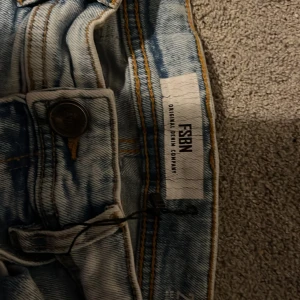 Ljusblå slitna jeans från FSBN - STORLEK 27/30 Ljusblå jeans från FSBN med slitningar och trasiga detaljer på knän och lår. Jeansen har en skinny passform och klassisk femficksdesign. Snyggt tvättad denim med råa benslut för en trendig look.