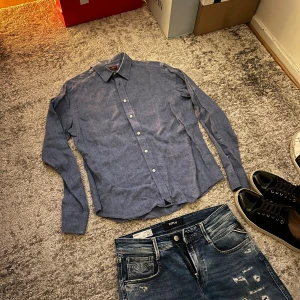 Blå linneskjorta  - Säljer denna ljusblå linneskjorta med klassisk krage och knäppning framtill. Skjortan är 100% linne och passar perfekt till ett par snygga jeans. Skjortans stilrena och tidslösa design gör att den funkar till alla tillfällen. Nypris 1000kr. Mitt pris 349. 