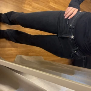 Svarta bootcut jeans  - Snygga svarta jeans med klassisk femficksdesign och bootcut-ben. Jeansen har en lågmidjad passform och är tillverkade i mjukt jeansmaterial som sitter skönt. Perfekta för dig som gillar en stilren look med lite extra edge.