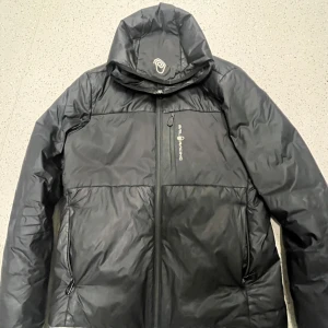 Svart pufferjacka Sail Racing M - Svart pufferjacka från Sail Racing, modell Glacier Primaloft Hood.  pris kan diskuteras 