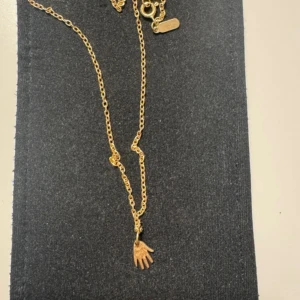 Maria Nilsdotter halsband  - Guldpläterat halsband från Maria Nilsdotter. Kedjan är 45cm lång. Materialet under pläderingen är silver. Ask följer med