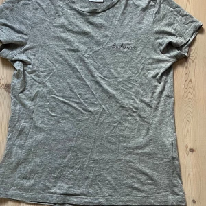 Grå t-shirt med broderad text - Snygg grå t-shirt i bomull med broderad text 'Be Aware' på bröstet. Klassisk passform och korta ärmar, perfekt till jeans eller shorts. Enkel och stilren design som funkar till det mesta.