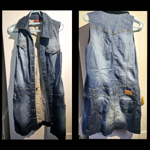 Ärmlös jeansklänning med fickor - Cool ärmlös jeansklänning från XX by Mexx med knappar framtill, klassisk krage och flera fickor både fram och bak. Snygga sömmar och slitningar ger en avslappnad vibe. Perfekt att styla med sneakers eller boots för en trendig look.