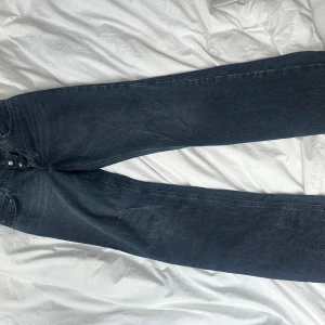 Mörkblå jeans från ASOS - Mörkblå jeans från ASOS DESIGN med raka ben och klassisk femficksdesign. Jeansen har normal passform och är tillverkade i ett robust denimtyg. Perfekta för dig som gillar en enkel och stilren look.