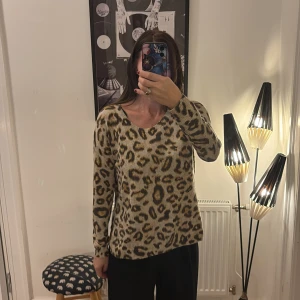 Leopardmönstrad stickad tröja H&M M - Säljer en beige stickad tröja från H&M i storlek M med leopardmönster i brunt och svart. Tröjan har rund halsringning, lång ärm och en snygg dragkedja bak i nacken. Perfekt för dig som gillar djurmönster och vill sticka ut lite extra.