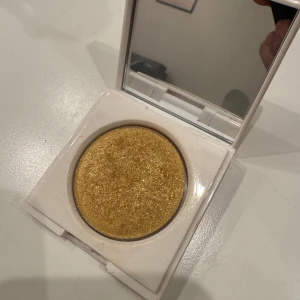 Makeup By Mario highlighter Citrine - Säljer en Makeup By Mario Master Crystal Reflector highlighter i färgen Citrine. Kommer i en vit, fyrkantig dosa med spegel. Highlightern är pressad och har en intensiv guldig nyans med mycket glitter och kristallskimmer, perfekt för att ge ansiktet extra glow. (öppnad ej använd) 