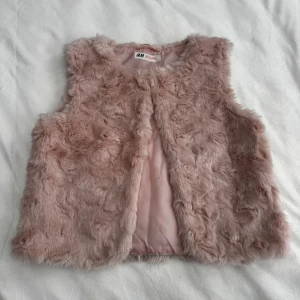 Rosa fuskpäls väst - Lurvig rosa fuskpäls väst från H&M i storlek 140. Fraktar inom 24h!