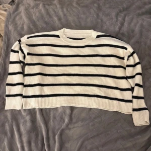 Randig stickad tröja - Säljer en vit stickad tröja från shein med svarta horisontella ränder. Tröjan har rund halsringning, långa ärmar och ribbade muddar vid ärmslut och nederkant. Perfekt för dig som gillar en klassisk och chill stil.