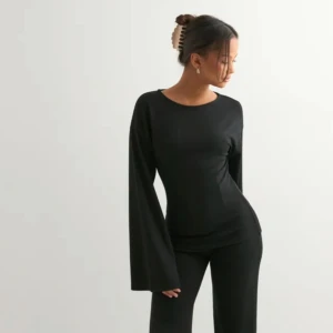 Svart långärmad topp med vida ärmar - Säljer en svart långärmad topp med riktigt snygga vida ärmar. Toppen har en rund halsringning och är figurnära i passformen, vilket ger en clean och stilren look. Perfekt att matcha med både jeans och kostymbyxor för en trendig vibe. Ny pris 349kr.