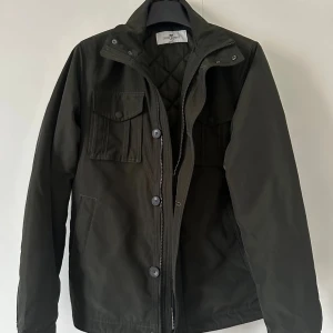 John Henric Field jacka (höst/vinter)  - Hej! Säljer en John Henric Field jacket, som passar för både höst och vinter då den är fodrad. Den är storlek XS/S. Skulle säga mer S. Jag är vanligtvis medium, är 188 och 84kg, sitter en aningen tight i ryggen på mig. Så är du runt om där eller en aningen kortare kommer den sitta perfekt. Sjukt snygg militär grön färg. Helt perfekt skick och inga defekter, då den knappt är använd. Nypris var 1500