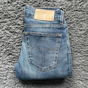 Blå skinny jeans från Tiger of Sweden - Snygga blå jeans från Tiger of Sweden med klassisk femficksdesign och ljusa slitningar. Modellen är tight och har smala ben, perfekt för dig som gillar en slim och modern look. Jeansen är i stretchigt denim för extra komfort.
