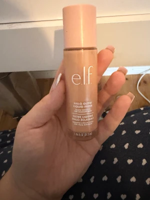 e.l.f. Halo Glow Liquid Filter Shade 3 - Glow booster från e.l.f. i färgen Shade 3 Light/Medium. Flytande formula som ger en strålande finish och kan användas som foundation, highlighter eller primer. Kommer i en snygg beige och rosa flaska med skruvlock, innehåller 31,5 ml.