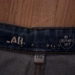 Blå skinny jeans LAB industries - Snygga blå jeans från LAB i storlek 158. Modellen är skinny med smal passform och klassisk femficksdesign. Jeansen har en cool tvätt med ljusare partier framtill och baktill, vilket ger en trendig look. Perfekt för dig som gillar stilrena och moderna jeans.