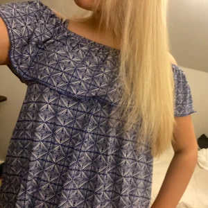 Blå volang blus - Säljer en blå blus med geometriskt mönster. Blusen är off shoulder💗