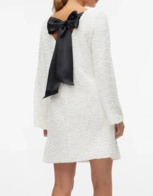 Vit paljettklänning med svart rosett stl xs Ny - Säljer en vit glittrig klänning täckt av paljetter med trekvartsärm och en stor svart rosett i nacken. Klänningen har en rak passform och är perfekt för dig som vill sticka ut. Endast provad ny