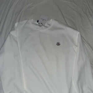 Vit sweatshirt från Moncler - Helt ny vit sweatshirt från Moncler som jag nu säljer för att den inte passar mig. Tröjan är helt ny med prislapp. Jag vill sälja den snabbt därav priset.