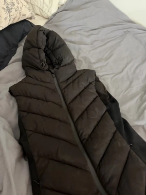 Svart lång dunväst med huva - Säljer en svart Zara väst jätte bra sick, använt 2 gånger storlek S!